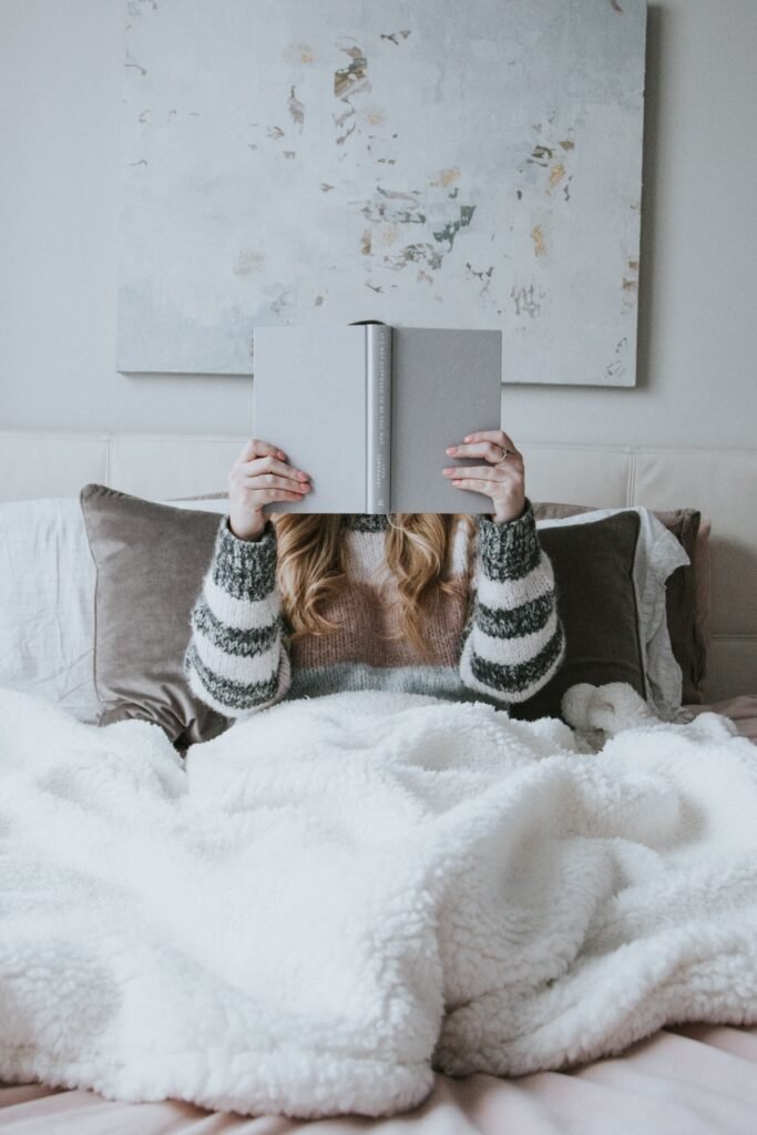 Girl reading a book in bed 